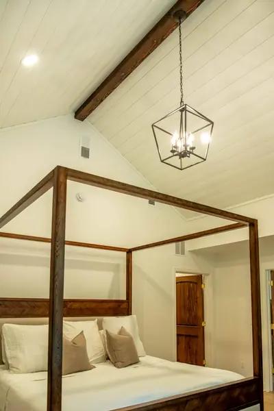 Vaulted shiplap ceiling with a stained exposed beam and lantern pendant
