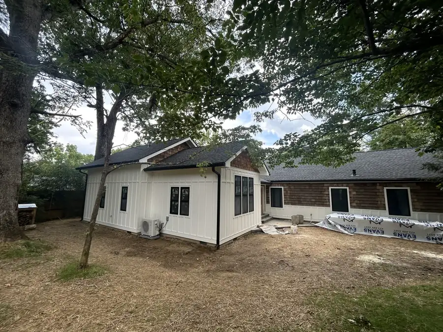 White board-and-batten home addition with cedar shake accents built by Riverside Construction Services