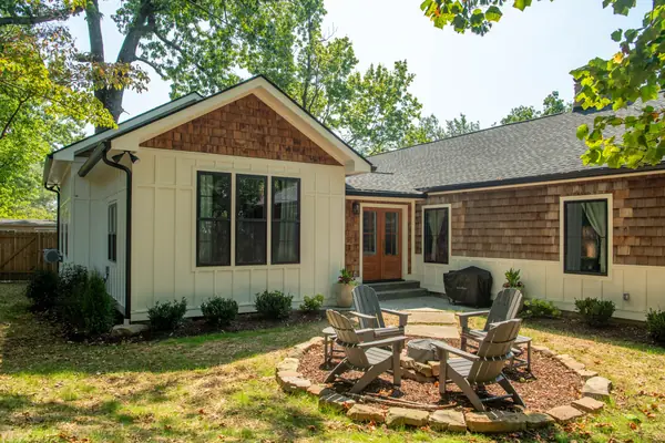 Stone fire pit and Adirondack chairs on the patio behind the addition