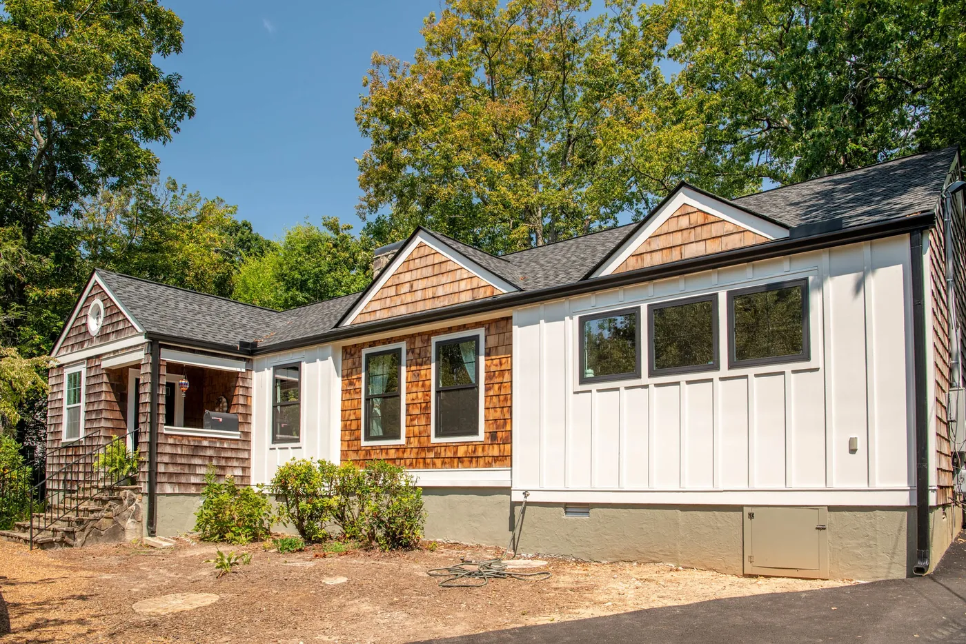 Renovated home exterior with board-and-batten siding beneath cedar shake gables