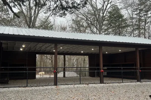 The finished pole barn with its standing-seam metal roof and open equipment bays