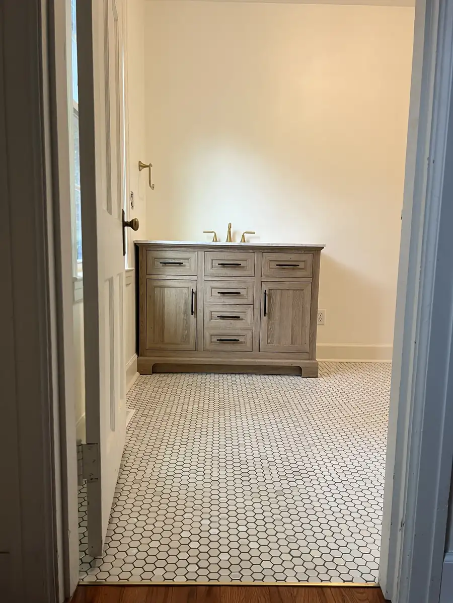 Bathroom with wood vanity and hexagon tile floor