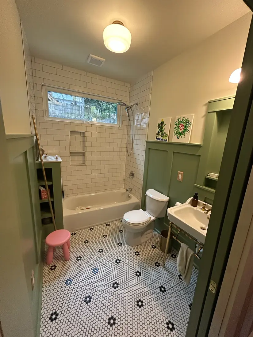 Craftsman bathroom remodel with green board-and-batten trim, subway tile and hex floor