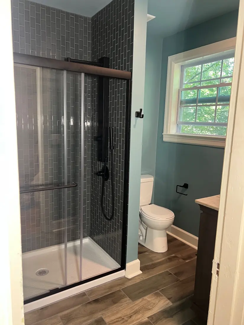Bathroom remodel with dark tile shower and matte black fixtures