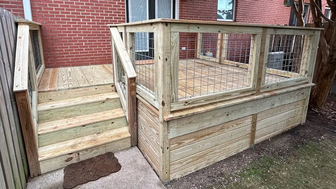 Pressure-treated deck with wire mesh railing