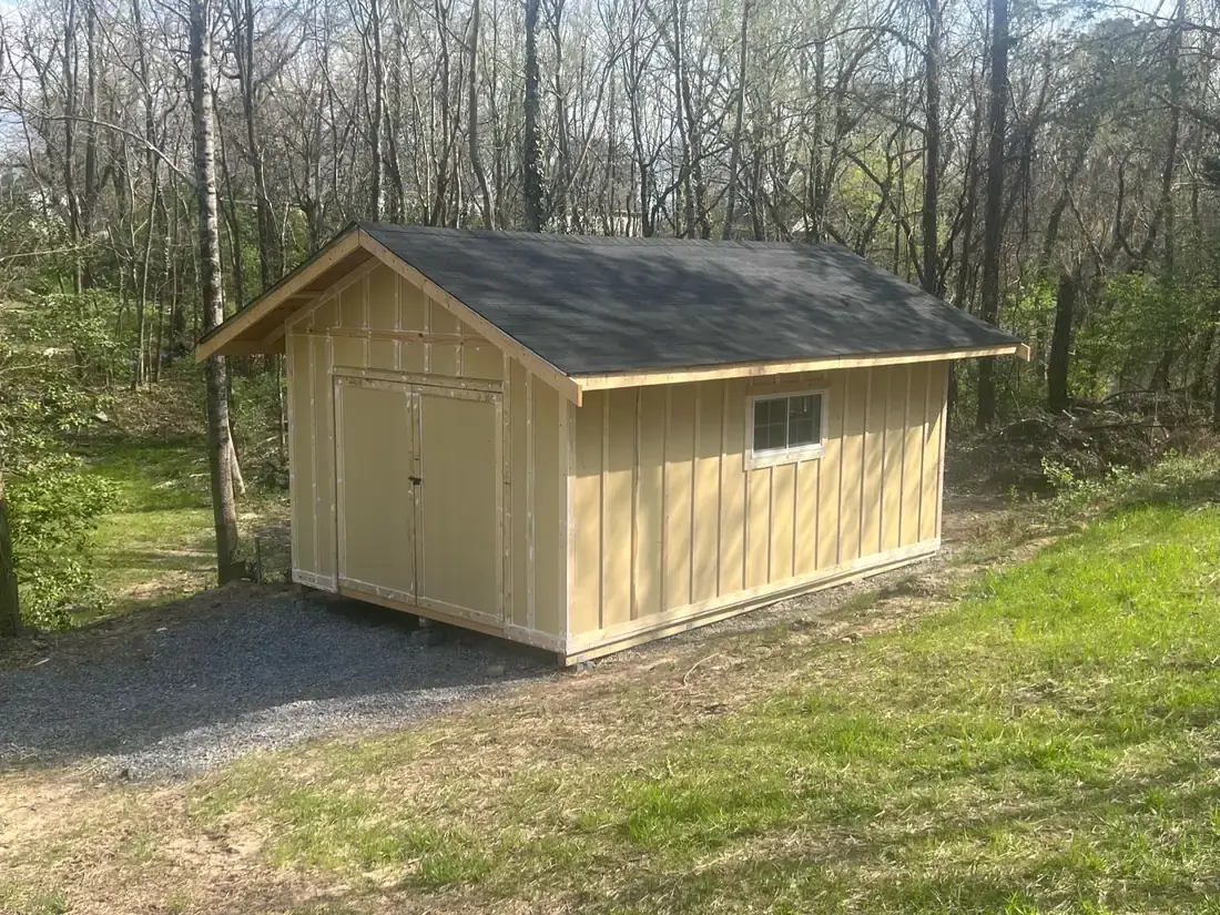 The same shed during construction, sheathed and roofed before siding and paint